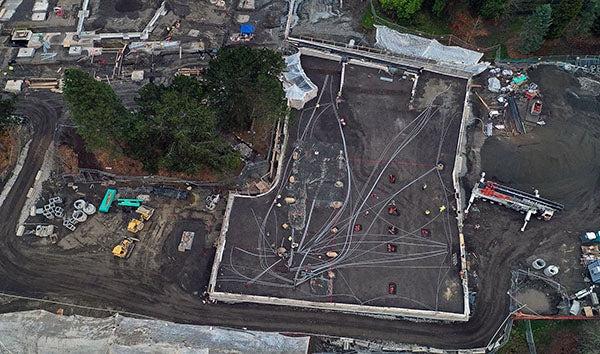 aerial view of a construction site with the building shape outlined with concrete walls